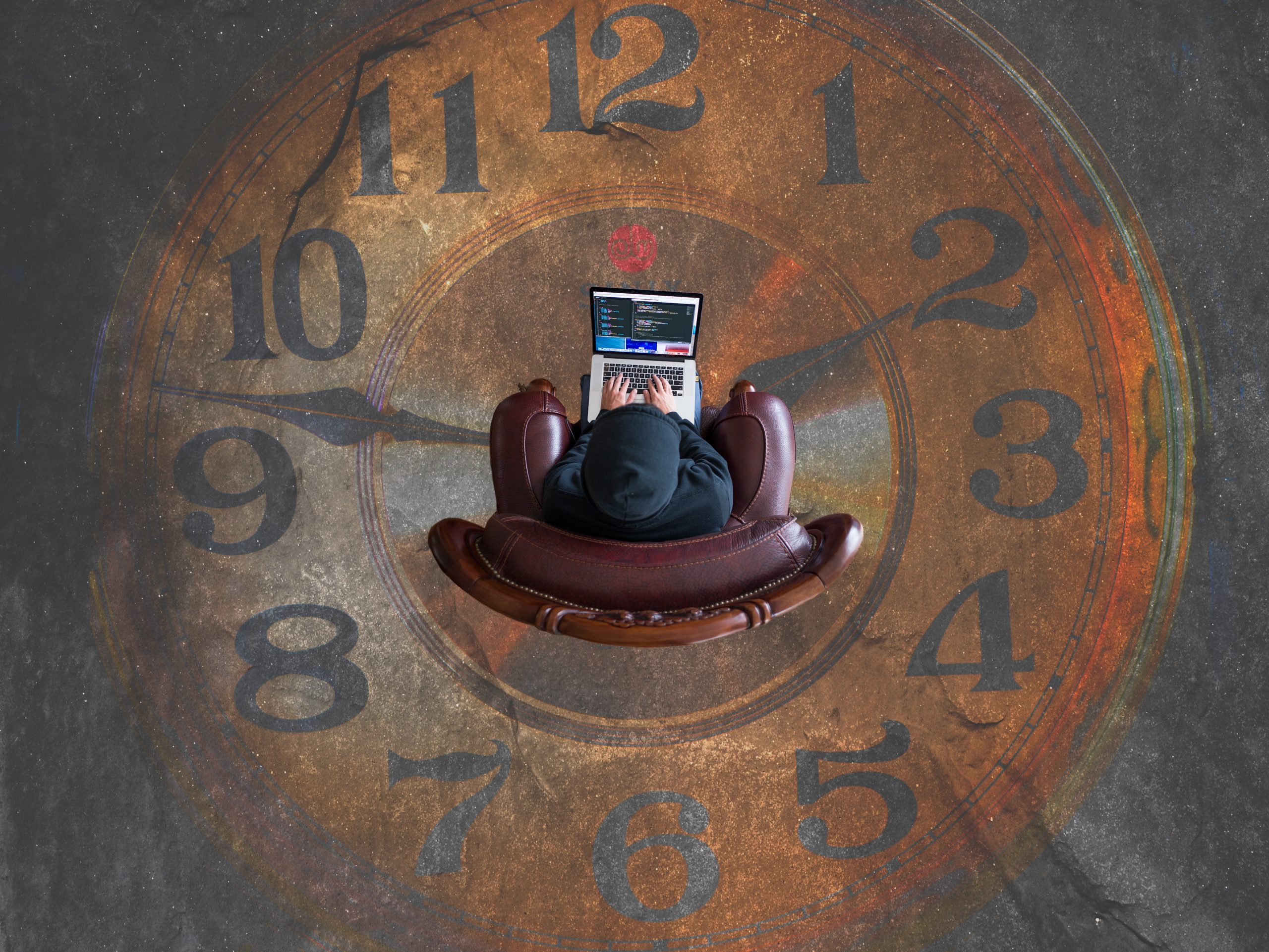 person-using-computer-in-centre-of-an -analog-clock